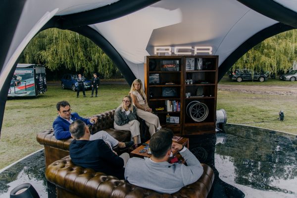 RCR team engaging in conversations with guests at the brand’s outdoor lounge during a lifestyle automotive event.