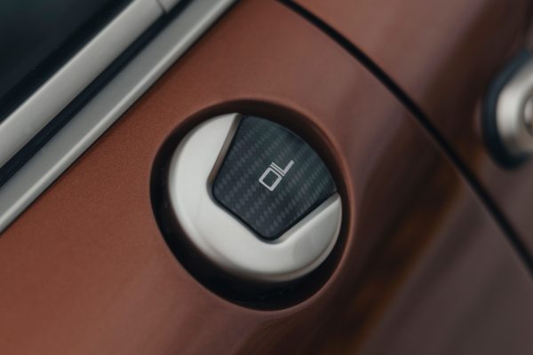 Wlew oleju z karbonowym wykończeniem w brązowym Porsche 911 restomod.